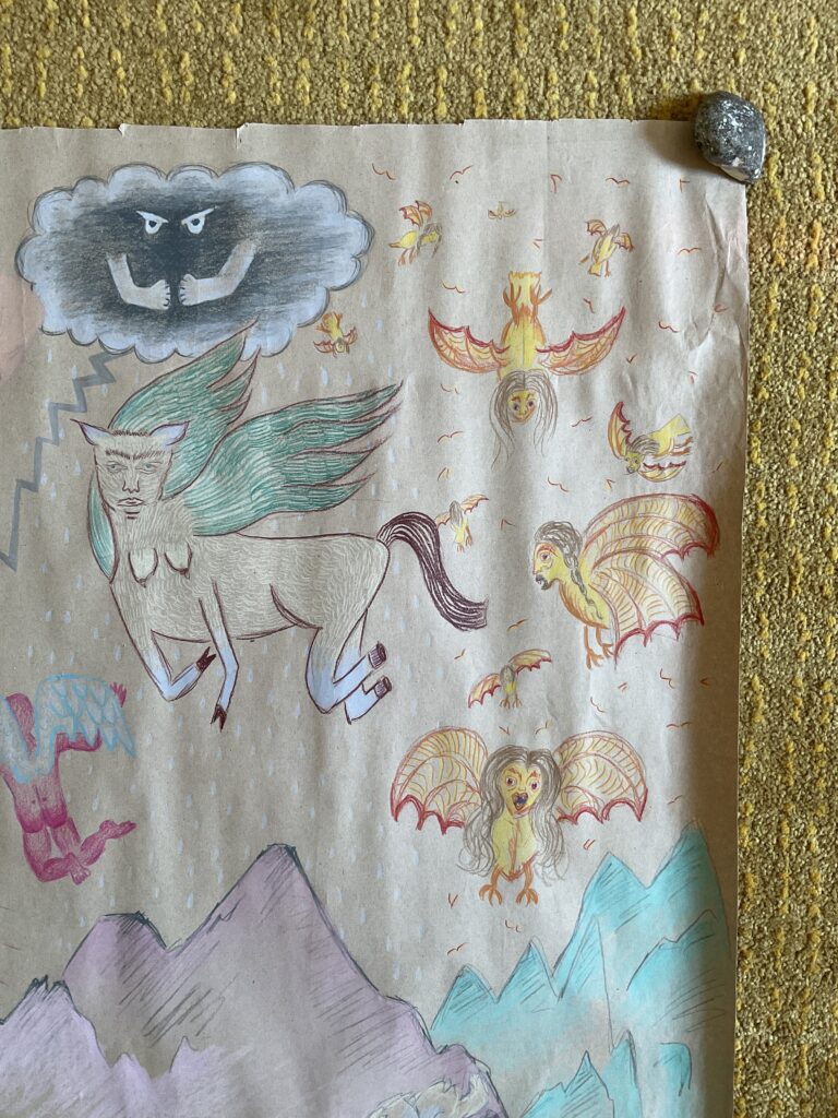 Dessin sur papier craft brun de forme carré au crayon de bois de couleurs. La scène montre des dragons dans le ciel, une créature ailée, un nuage fâché et des sirènes volantes surplombant un lac au fond duquel un enfant semble dormir, une montagne mauve avec des loups blancs et gris et des montagnes turquoises.